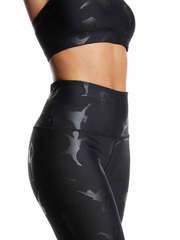 Model is wearing Lukafit squat-proof legging in Black on Black color. Photo is a side profile view of her upper legs and chest in front of a white background